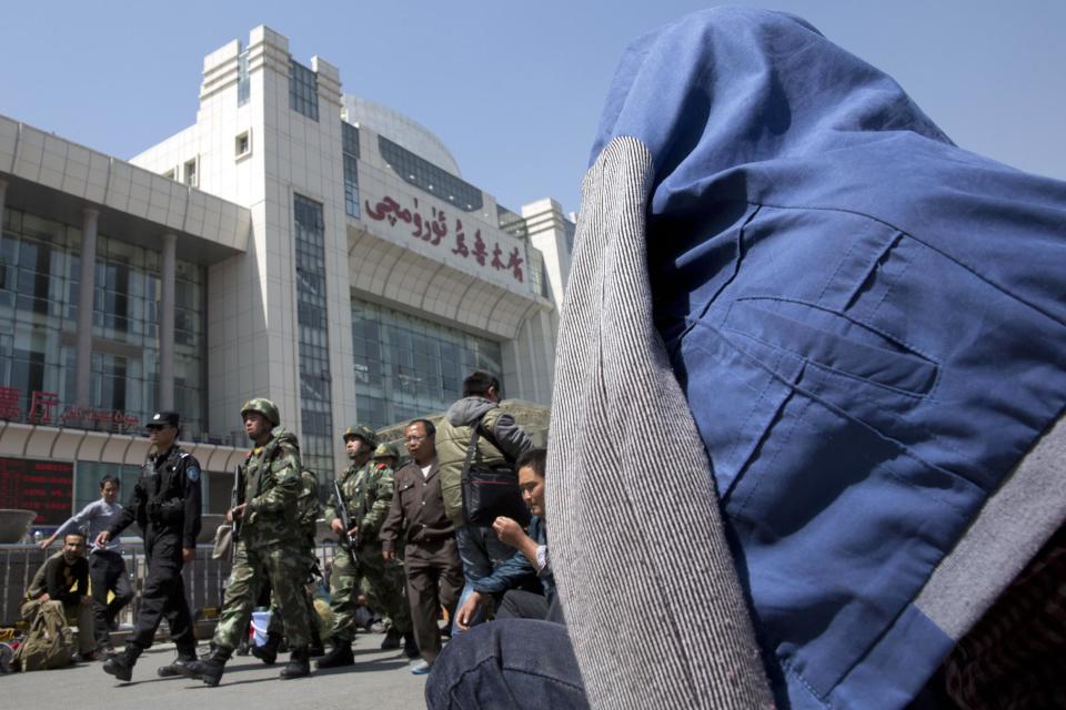 Heavily armed Chinese paramilitary police men march past the Urumqi South Railway Station a day after an explosion nearby in Urumqi in northwest China's Xinjiang Uygur Autonomous Region on Thursday, May 1, 2014. Chinese President Xi Jinping demanded “decisive” action against terrorism after a slashing and bomb attack at a Xinjiang train station killed three people and injured 79 while the leader was wrapping up a tour of the far-western region. (AP Photo/Ng Han Guan)