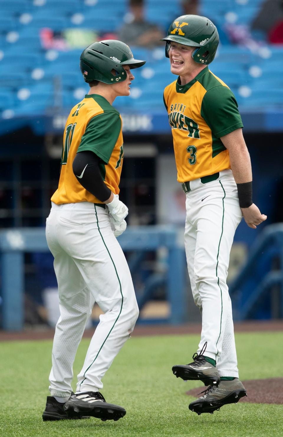 Louisville St. Xavier High's Cooper Smith, right, celebrates with teammate Landon Akers, left, after bringing in a run against McCracken County in the Kentucky State baseball semi-final game. June 10, 2022