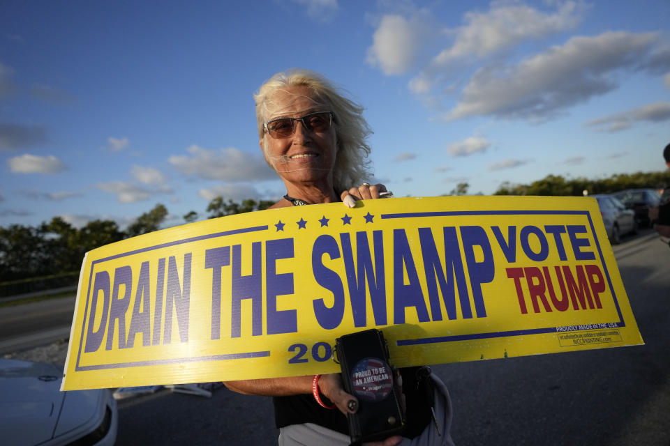 Liz DePiro, 67, of Deerfield Beach, Fla., holds a sign as she demonstrates to show support for former President Donald Trump a day after he was indicted by a Manhattan grand jury, Friday, March 31, 2023, near Trump's Mar-a-Lago estate in Palm Beach, Fla. (AP Photo/Rebecca Blackwell)