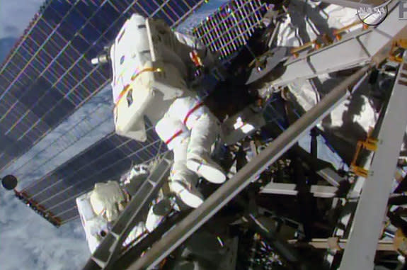 NASA astronauts Terry Virts (center) and Butch Wilmore work to route cables outside the International Space Station during their third spacewalk together on March 1, 2015.