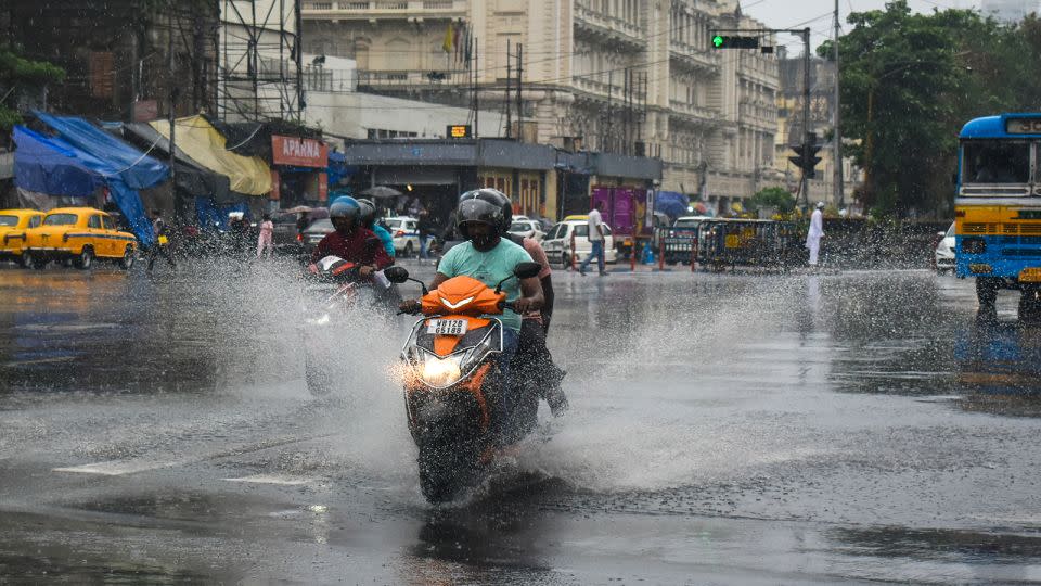 People are riding on a scooter as rains hit Kolkata, India ahead of Cyclone Remal's landfall on May 26, 2024. - Sudipta Das/NurPhoto/Getty Images