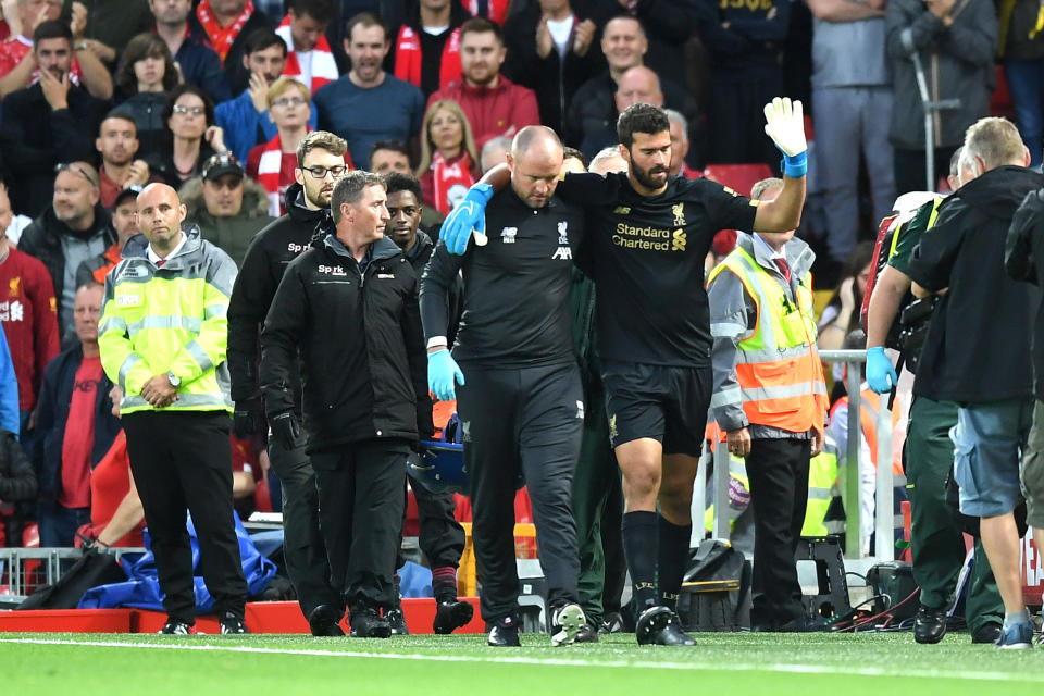 Alisson Becker leaves the pitch following an injury during the Premier League opener. (Photo by Michael Regan/Getty Images)