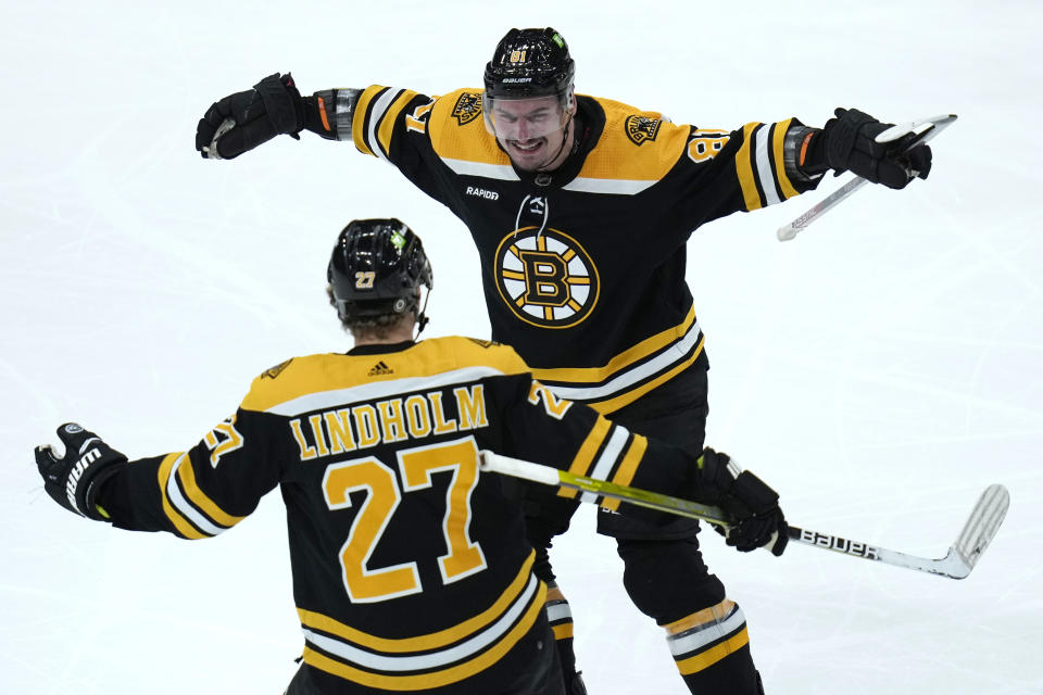 Boston Bruins defenseman Dmitry Orlov, top, is congratulated by Hampus Lindholm (27) after his goal against the Buffalo Sabres during the second period of an NHL hockey game, Thursday, March 2, 2023, in Boston. (AP Photo/Charles Krupa)