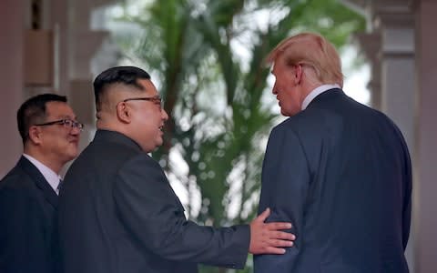 North Korea leader Kim Jong Un and U. S. President Donald Trump stand together at the Capella resort on Sentosa Island  - Credit: AP