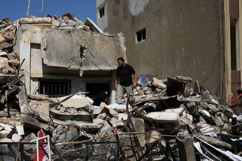 Syrian refugee Ahmed Staifi walks among the debris of a house were his wife and two of his daughters were killed following a massive explosion, in Beirut
