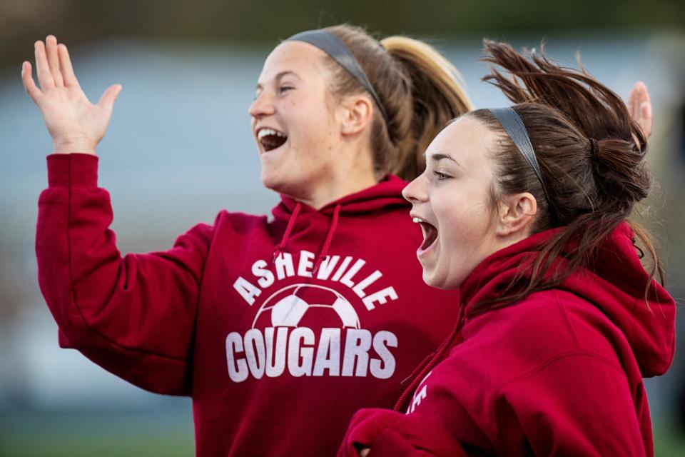 Asheville Cougars cheer from the sidelines after their team scored another goal in the game at Roberson High School March 29, 2023.