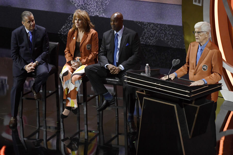 Del Harris speaks during his enshrinement at the Basketball Hall of Fame as presenters John Calipari, Nancy Lieberman and Sidney Moncrief, from left, listen Saturday, Sept. 10, 2022, in Springfield, Mass. (AP Photo/Jessica Hill)