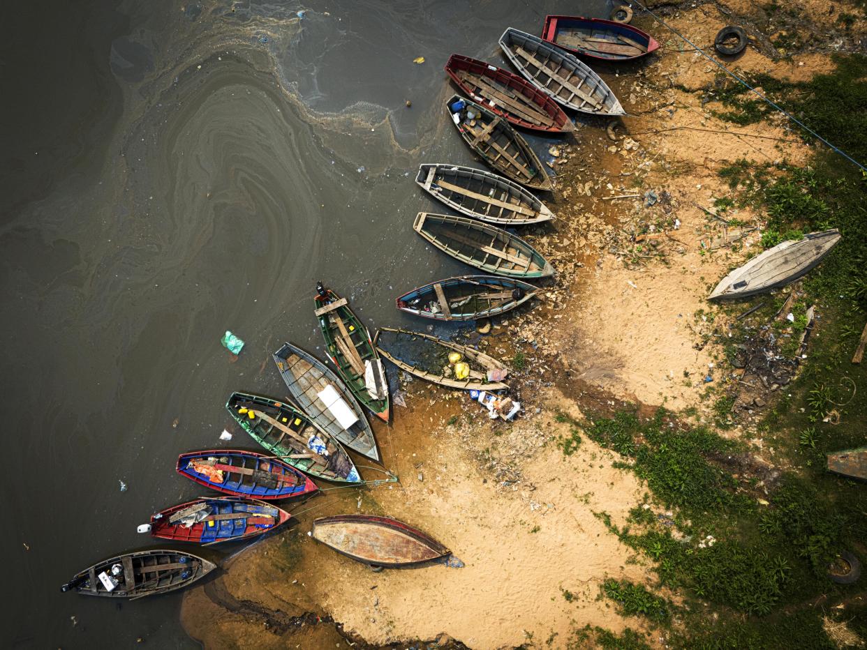 Fishing boats sit on the shore of the Paraguay River in Mariano Roque Alonso, Paraguay, Monday, Sept. 9, 2024. Water levels have plunged to their lowest-ever level amid a drought, according to Paraguay's Meteorology and Hydrology Office. (AP Photo/Jorge Saenz)