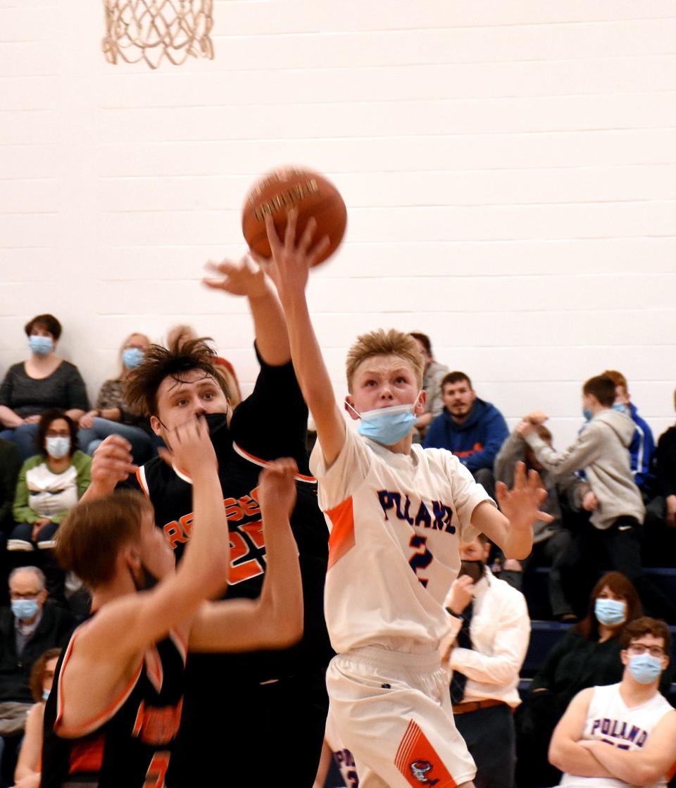 Poland's Carter Cookinham (2) goes up for a shot with Grady Helmer and Jonathan Jewett (from left) defending for Remsen during the second half of Tuesday's game.