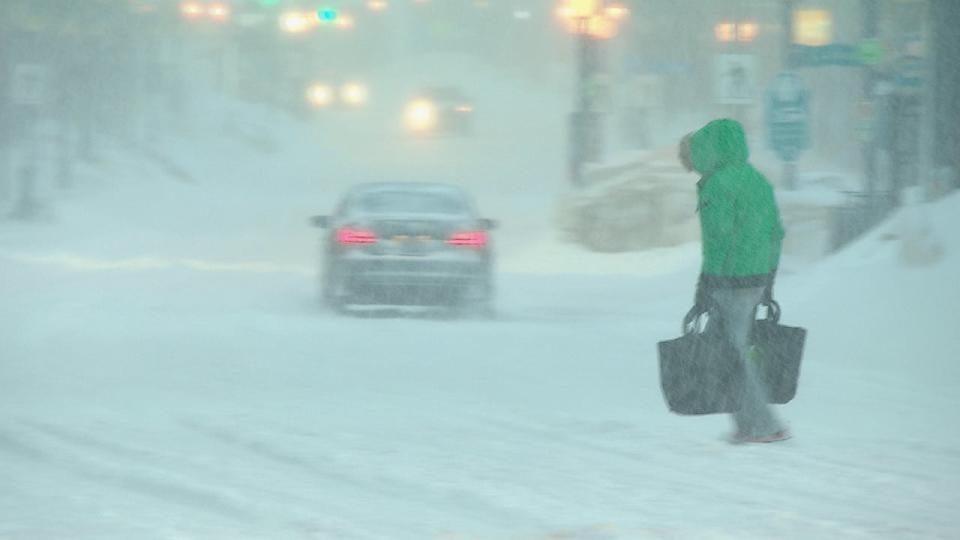 A pedestrian navigates snow-clogged streets in Moncton on Friday afternoon.