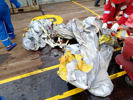 Workers of PT Pertamina examine recovered debris from what is believed to be the crashed Lion Air flight JT610, onboard Prabu ship owned by PT Pertamina off the shore of Karawang regency, West Java province, Indonesia, October 29, 2018. Antara Foto/PT Pertamina/Handout via REUTERS