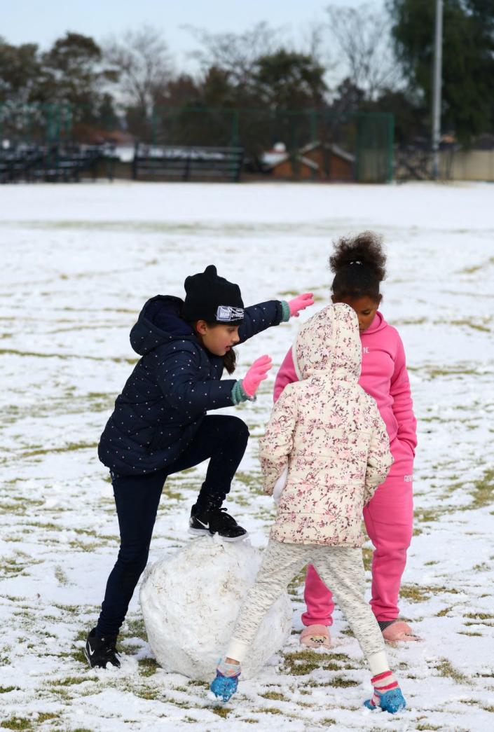 Girls play with a large snowball at a school in Brackenhurst, south of Johannesburg, on July 10.