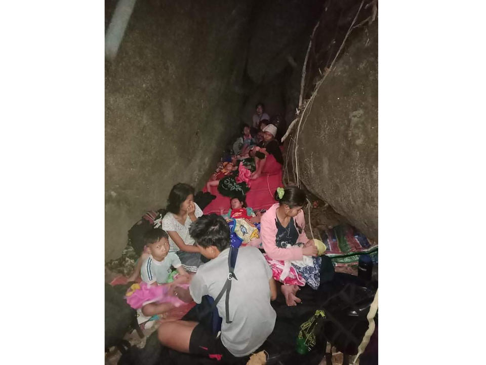 In this photo provided by Free Burma Rangers, villagers shelter in the open due to airstrikes, Saturday, March 27, 2021, in Deh Bu Noh, in Karen state, Myanmar. Myanmar military jets hit a village in Karen State, on Saturday night, killing a few people and wounding others, according to relief organizations.(Free Burma Rangers via AP)