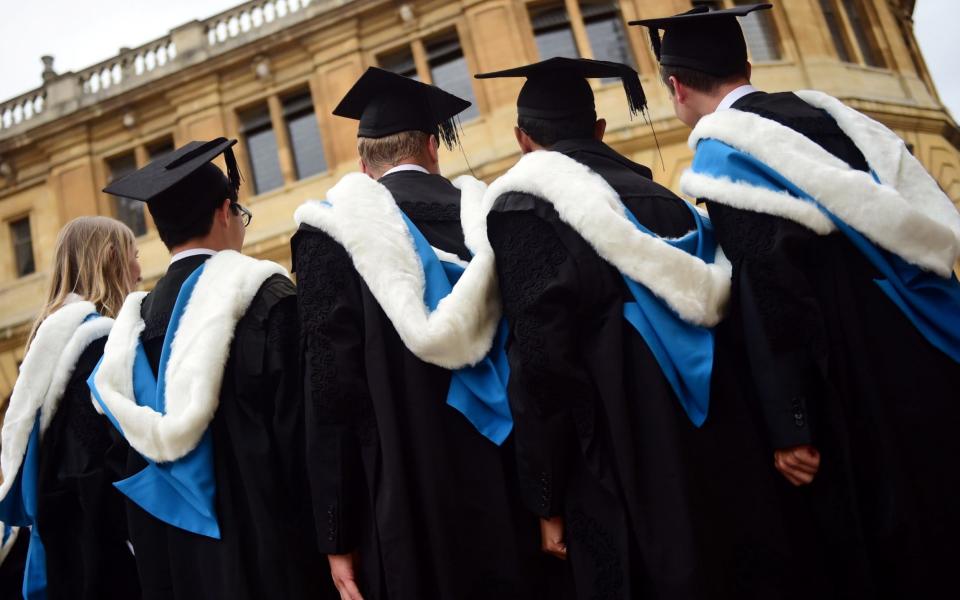 Graduates pose for a photograph outside the Sheldonian Theatre after a graduation ceremony at Oxford University - Credit: Reuters