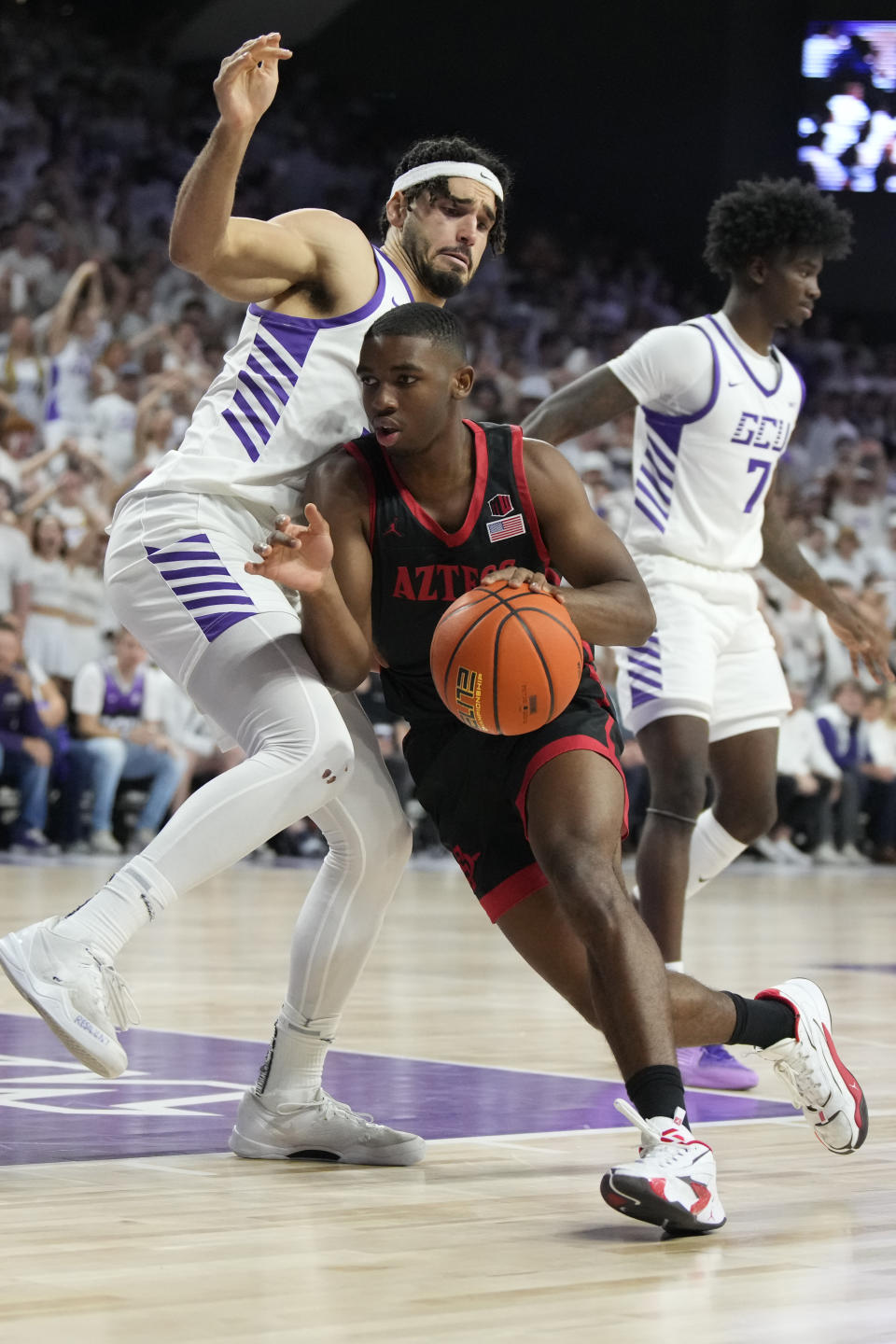 San Diego State guard Lamont Butler drives past Grand Canyon forward Gabe McGlothan, left, during the first half of an NCAA college basketball game Tuesday, Dec. 5, 2023, in Phoenix. (AP Photo/Rick Scuteri)