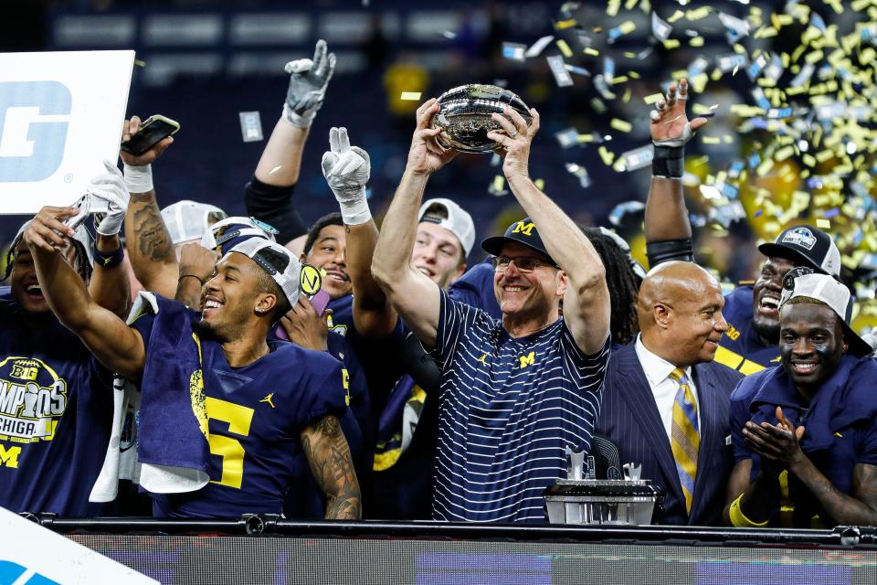 Michigan head coach Jim Harbaugh raises the Big Ten Championship trophy after the Wolverines defeated Purdue 43-22 at Lucas Oil Stadium in Indianapolis, Ind., on Saturday, Dec. 3, 2022.