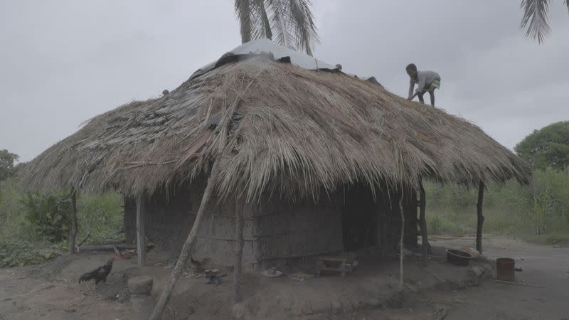 Teenager works on the roof of his house as Storm Freddy is due to hit Mozambique again