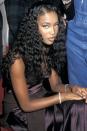 <p>Naomi Campbell backstage at the 1997 show wearing long curls, pink blush, and major lashes.</p>