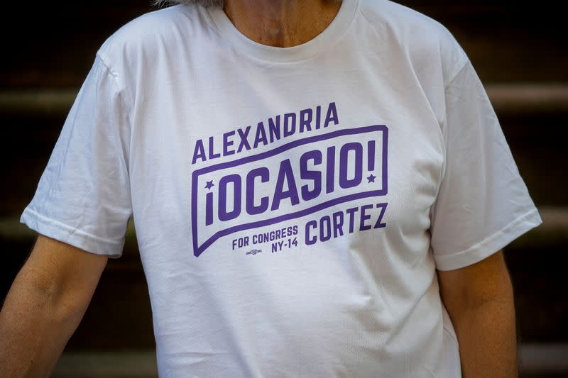 Peter Hogness poses wearing his Alexandria Ocasio-Cortez branded T-shirt in the Park Slope area of Brooklyn, New York