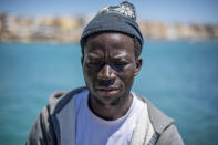 Waly Sarr, 30, from Senegal, poses for a photo on the deck of the "Vincenzo Padre" fishing boat where he works as fisherman, in the Island of Lampedusa, southern Italy, Thursday, May 13, 2021. The tiny island of Lampedusa, which is closer to Africa than the Italian mainland, is in the throes of yet another season of migrant arrivals, and Sarr and his fellow countryman Ibrahima Mbaye can only watch from shore as their fellow African countrymen risk their lives to get here via smugglers' boats. (AP Photo/Salvatore Cavalli)