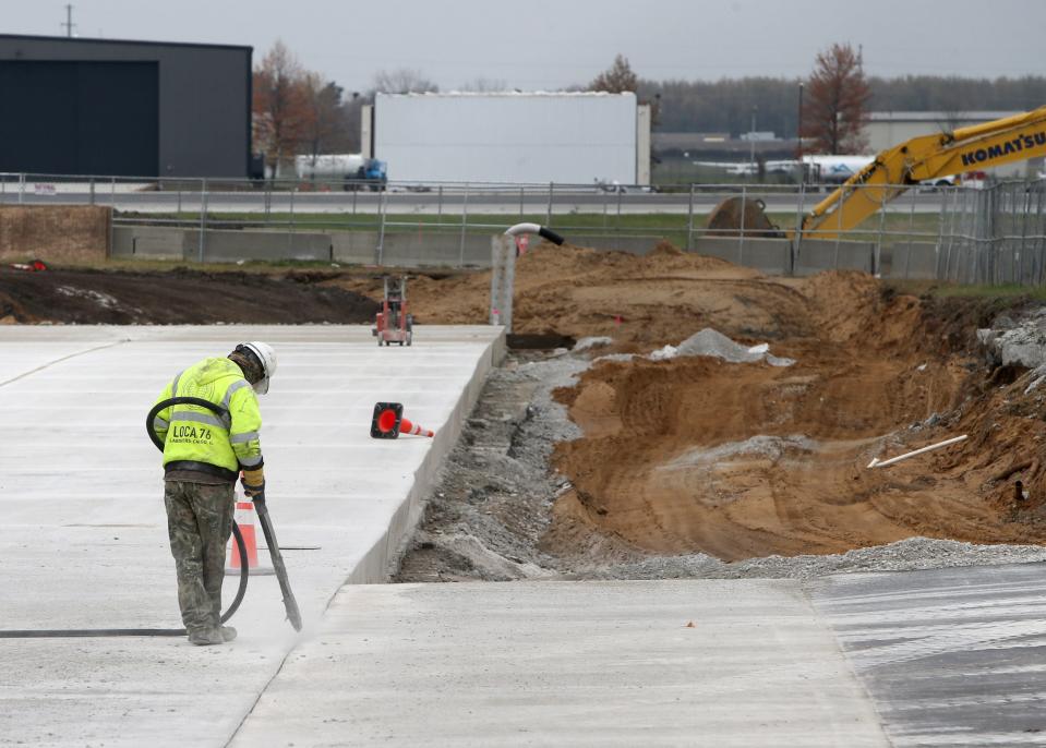 A worker uses an air blaster during a multi-year tarmac and ramp replacement project Wednesday, Nov. 8, 2023, at the South Bend International Airport.