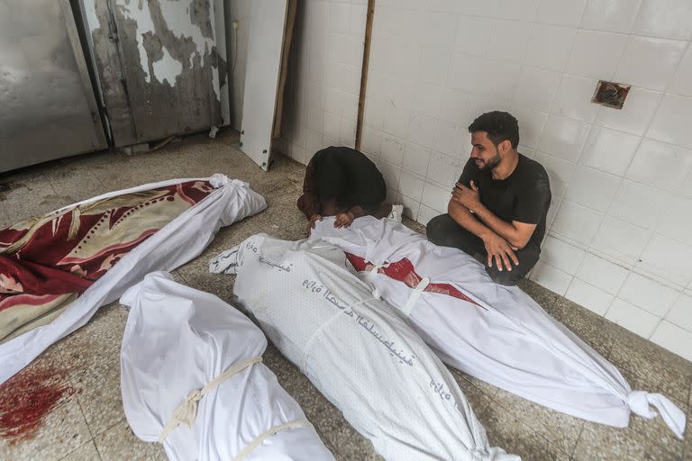Palestinos lloran a sus familiares en el hospital Al-Aqsa tras un bombardeo israelí.