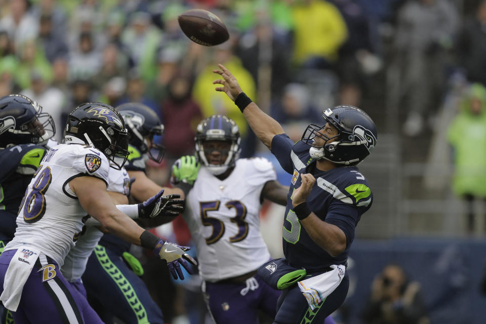 Seattle Seahawks quarterback Russell Wilson (3) passes under pressure from Baltimore Ravens linebacker L.J. Fort, left, during the first half of an NFL football game, Sunday, Oct. 20, 2019, in Seattle. (AP Photo/John Froschauer)