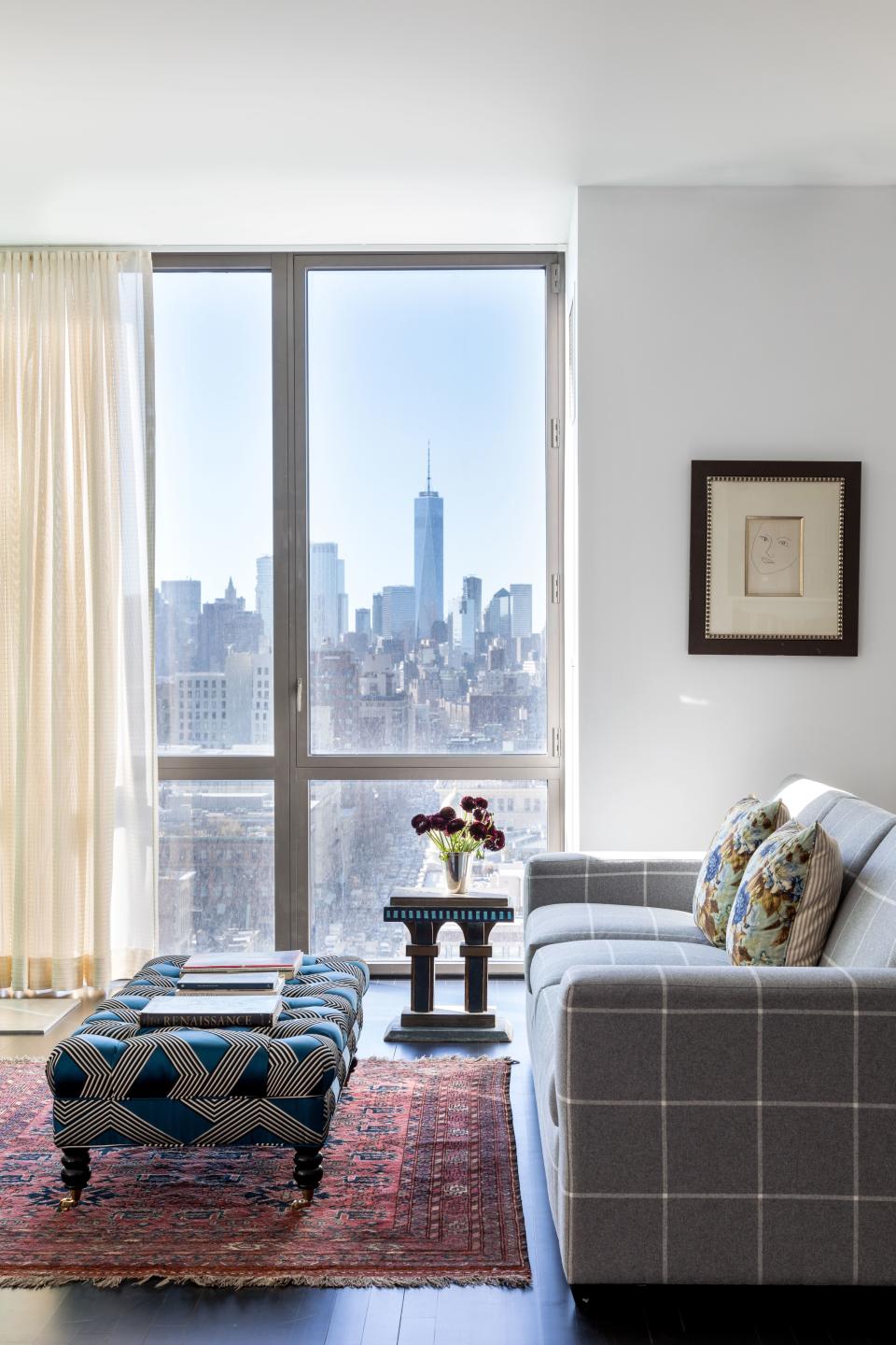 One side of the large living room contains a custom sofa in cozy Ralph Lauren flannel, plus a vibrant tufted ottoman finished in Dedar Milano fabric and Matisse drawing the couple had previously inexplicably hidden in a back hallway. “We moved it there to make it a little more prominent,” says McGrath.