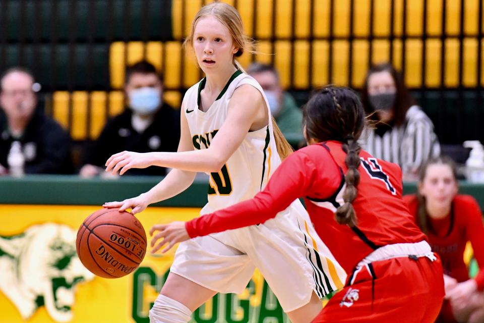 Salina South guard Kylie Arnold (10) dribbles around Liberal's Lizzy Cisneros (4) Thursday night in the Salina Invitational Tournament.