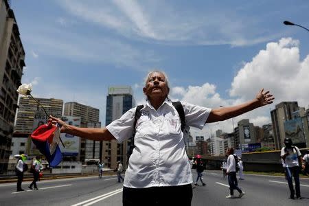 A woman lifts her arms in front of riot policemen (not pictured) during a women's march to protest against President Nicolas Maduro's government in Caracas, Venezuela, May 6, 2017. REUTERS/Carlos Garcia Rawlins