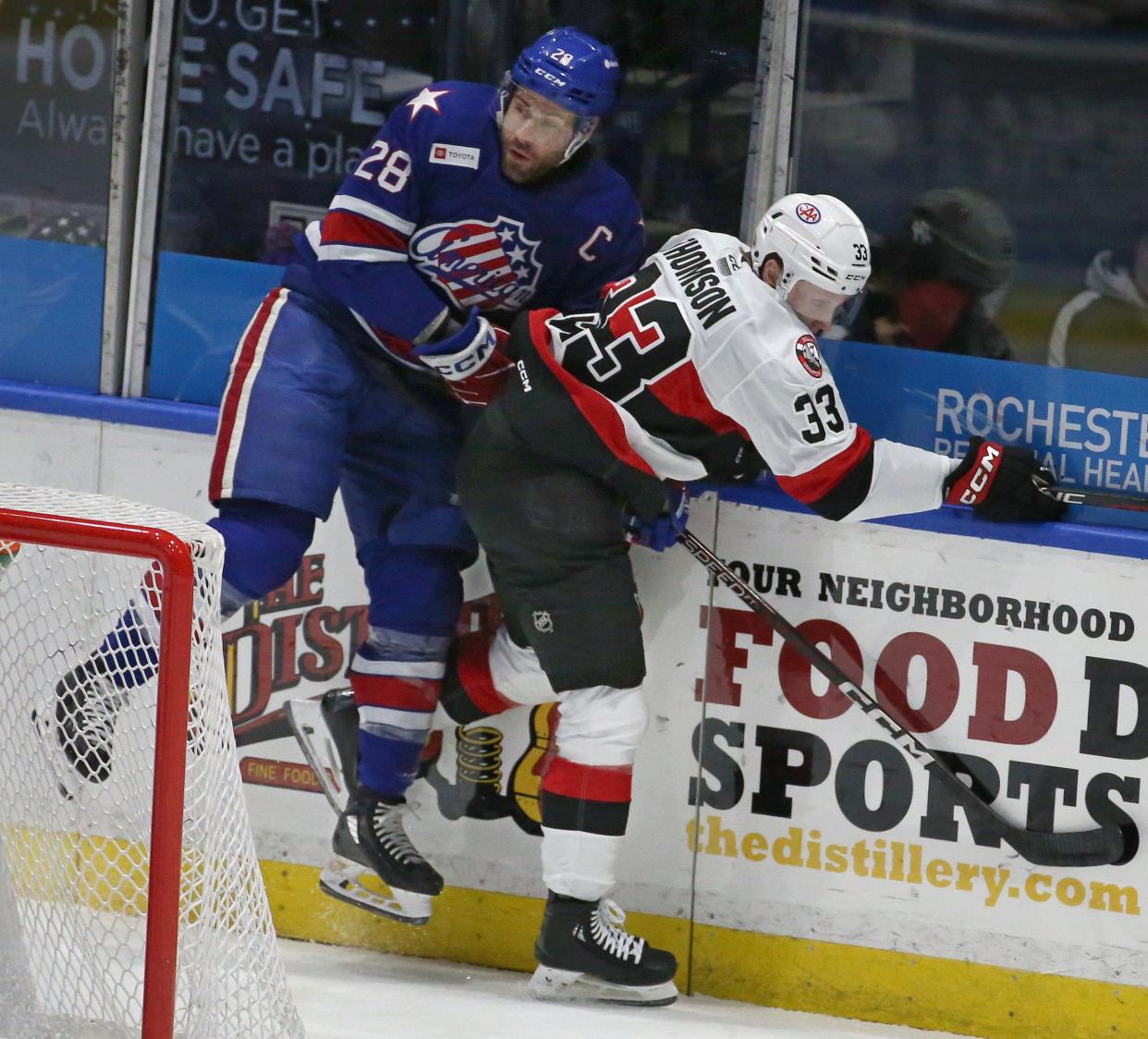 Rochester's Michael Mersch checks Belleville's Lassi Thomas hard into the boards behind the Belleville net during their AHL hockey game Wednesday, Feb. 21, 2024 at the Blue Cross Arena.