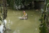 A girl uses a raft to cross the flooded area, in a flood affected village in Morigaon district of Assam, in India on Monday, 20 July 2020. (Photo by David Talukdar/NurPhoto via Getty Images)