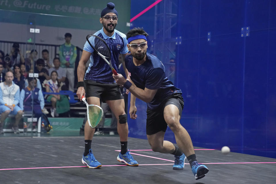 Malaysia's Mohammad Syafiq Bin Mohd Kamal, right, and India's Harinder Pal Singh Sandhu compete during the mixed doubles squash final at the 19th Asian Games in Hangzhou, China, Thursday, Oct. 5, 2023. (AP Photo/Aijaz Rahi)