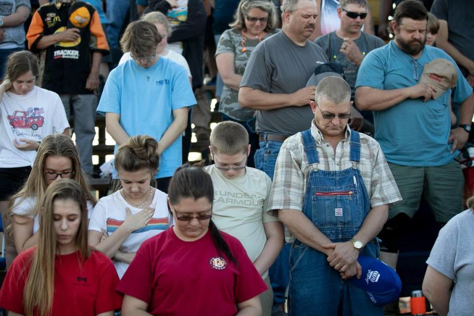 Scott Tate, right, of Concord, Va., bows his head in prayer with others before the first race at Ace Speedway on Saturday, May 23, 2020 in the Altamahaw community near Elon, N.C.