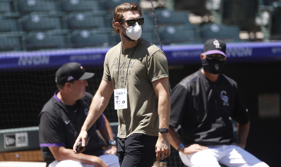 Colorado Rockies left fielder David Dahl, front, passes by bench coach Mike Redmond, back left, and manager Bud Black as the team practices Wednesday, July 8, 2020, in Denver. (AP Photo/David Zalubowski)