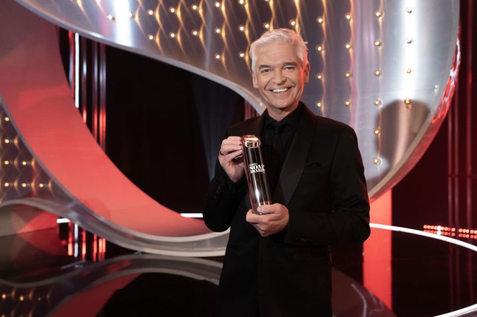 Phillip Schofield holding one of the covered British Soap Awards