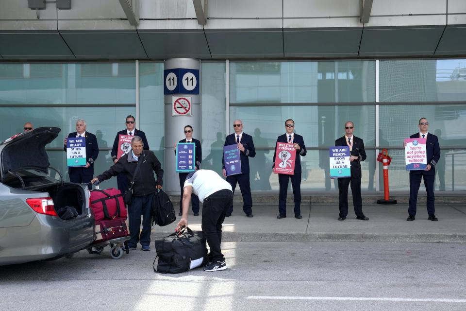 WestJet Airlines pilots stand on a picket line at Toronto’s Pearson Airport on May 8, 2023. THE CANADIAN PRESS/Chris Young