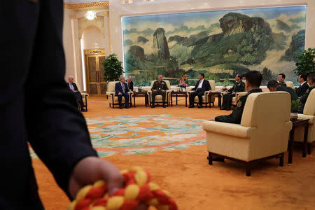 U.S. Chairman of the Joint Chiefs of Staff Gen. Joseph Dunford chats with President Xi Jinping as a security guard prepares to escort journalists out from a meeting room at the Great Hall of the People in Beijing, China August 17, 2017. REUTERS/Andy Wong/Pool