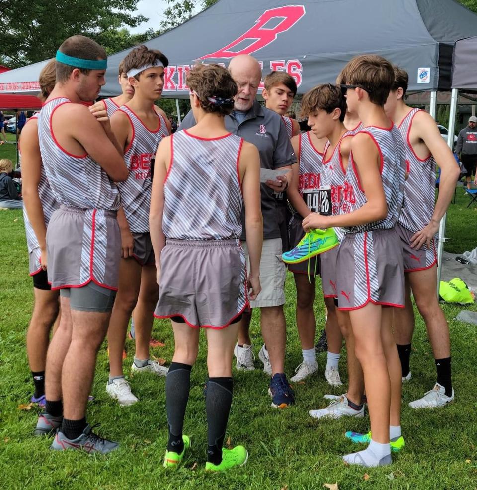 Coach Scott Earl (center) is shown Sept. 9 with members of the Bedford High School boys cross country team at the Tiffin Cross Country Carnival in Ohio. Earl died Monday.