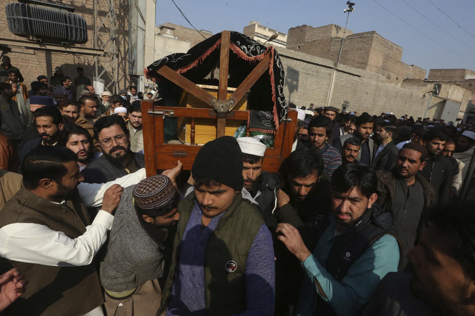 People carry the casket during a funeral for a police officer killed in Monday's suicide bombing inside a mosque, in Peshawar, Pakistan, Tuesday, Jan. 31, 2023. The death toll from the previous day's suicide bombing at a mosque in northwestern Pakistani rose to more than 85 on Tuesday, officials said. The assault on a Sunni Mosque inside a major police facility was one of the deadliest attacks on Pakistani security forces in recent years. (AP Photo/Muhammad Sajjad)