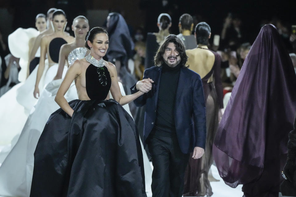 Stephane Rolland, and Nueves Alvarez, left, accept applause after the conclusion of the Stephane Rolland Spring-Summer 2022 Haute Couture fashion collection, in Paris, Tuesday, Jan. 25, 2022. (AP Photo/Francois Mori)