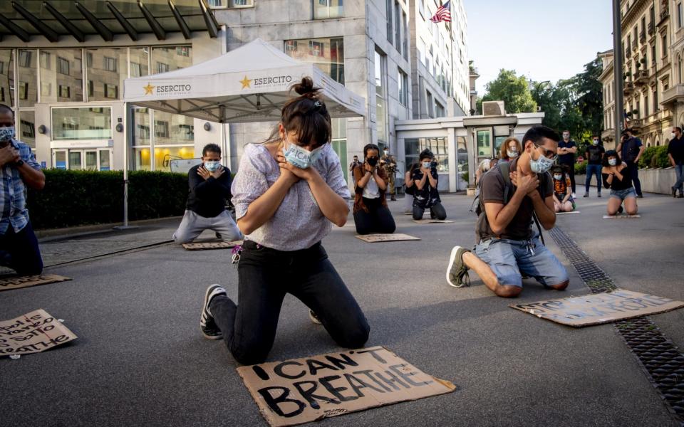 A flashmob of protesters outside the US consulate in Milan take a knee while holding their necks, symbolising the death of George Floyd - Francesco Prandoni/Getty Images Europe