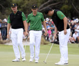 International team captain Ernie Els, left, looks over the 18th green with players Cameron Smith of Australia and Sung Jae Im of South Korea, right, in their foursomes match during the President's Cup golf tournament at Royal Melbourne Golf Club in Melbourne, Friday, Dec. 13, 2019. (AP Photo/Andy Brownbill)