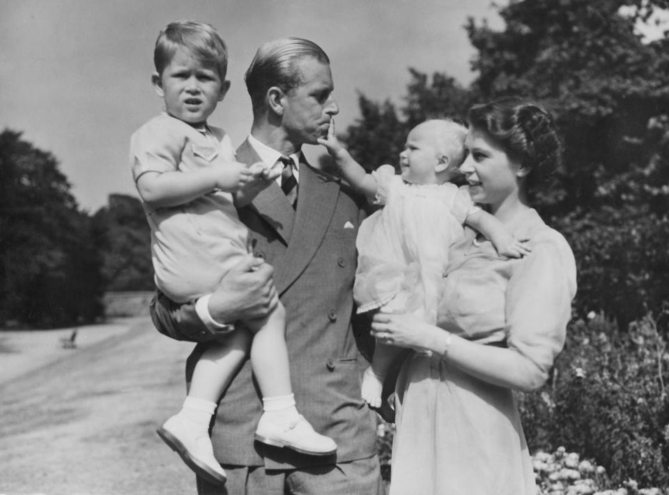 FILE - Britain's Queen Elizabeth II, then Princess Elizabeth, stands with her husband Prince Philip, the Duke of Edinburgh, and their children Prince Charles and Princess Anne at Clarence House, the royal couple's London residence, Aug. 1951, Queen Elizabeth II will mark 70 years on the throne Sunday, Feb. 6, 2022, an unprecedented reign that has made her a symbol of stability as the United Kingdom navigated an age of uncertainty. (AP Photo/Eddie Worth, File)
