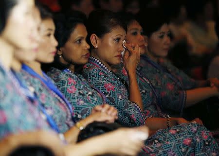 A Malaysia Airlines air stewardess wipes her eyes during a memorial for victims of MH370 and MH17 at Malaysia Airlines headquarters in Kuala Lumpur July 25, 2014. REUTERS/Olivia Harris