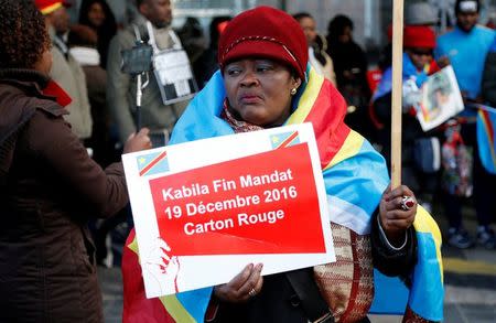 A demonstrator holds a sign reading "Kabila end of term - December 19, 2016 - Red card" during a protest against plans of Democratic Republic of Congo's President Joseph Kabila to stay in office past the end of his term, in central Brussels, Belgium, December 19, 2016. REUTERS/Francois Lenoir