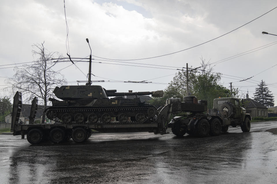 A military truck transports a platform with an Ukrainian self-propelled artillery vehicle in Donetsk region, Ukraine, on Monday, May 9, 2022.(AP Photo/Evgeniy Maloletka)