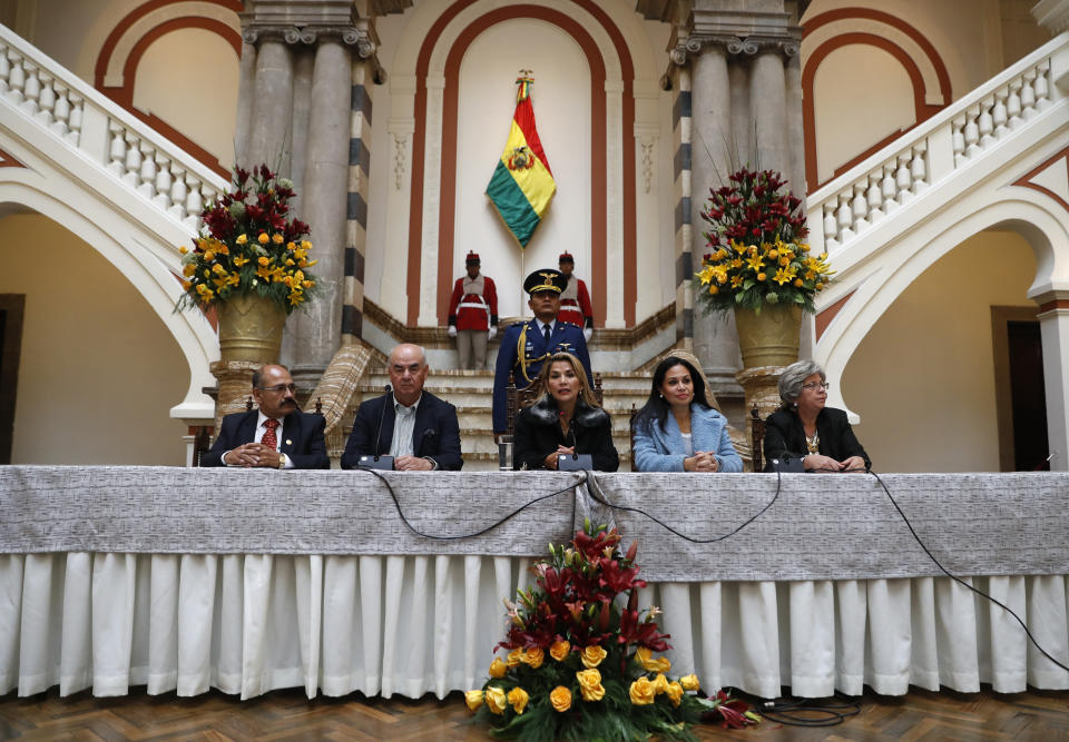 Bolivia's interim President Jeanine Anez, center, holds a press conference accompanied by Health Minister Anibal Cruz, from left, Economy Minister Jose Luis Parada, Communications Minister Roxana Lizarraga and Environment Minster Maria Elva Pinckert, in La Paz, Bolivia, Friday, Nov. 15, 2019. Anez, a Senate deputy leader who claimed the interim presidency, is moving to establish authority in the turbulent country. (AP Photo/Natacha Pisarenko)