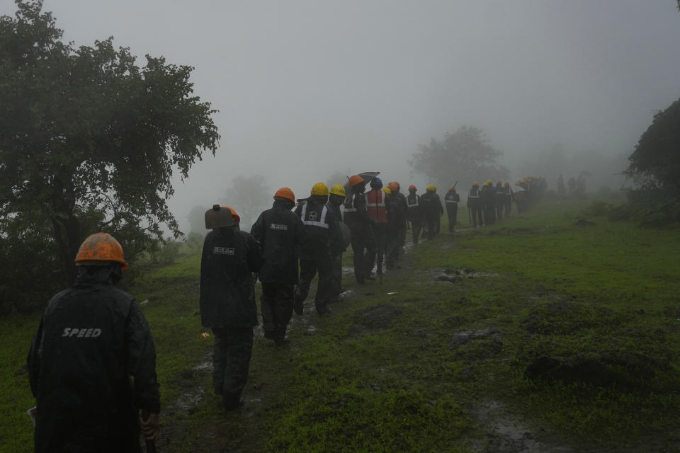 Rescuers walk towards the site of a landslide in Raigad district, western Maharashtra state, India, Thursday, July 20, 2023. While some people are reported dead many others feared trapped under piles of debris. (AP Photo/Rafiq Maqbool)