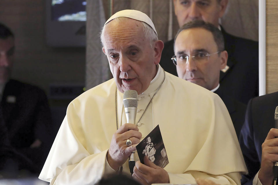 FILE - In this Jan. 15, 2018, file photo, Pope Francis holds a photo of U.S. photographer Joseph Roger O'Donnell of child victims of Nagasaki bombing, aboard his flight to Santiago, Chile. The Vatican said Friday, Sept. 13, 2019, Pope Francis will visit Thailand and Japan on Nov. 19-26. (AP Photo/Alessandra Tarantino, File)